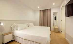 Ett hotellrum med två sängar täckta med vita sängkläder. (AI-genererad text)