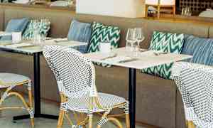 Restaurang med bordsuppsättning och kuddar. (AI-genererad text)