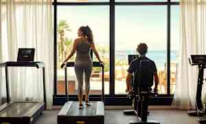 Gym med utsikt över havet genom stora fönster. (AI-genererad text)