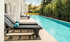Soldäck med solstolar vid en pool. (AI-genererad text)
