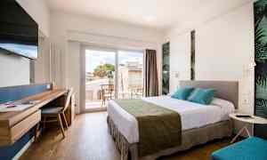 Ett ljus och modernt hotellrum med en stor säng, skrivbord, TV och en balkong med sittmöbler. (AI-genererad text)