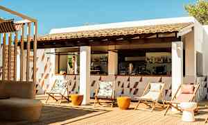 En utomhusbar med stolar och bord på en träterrass. (AI-genererad text)