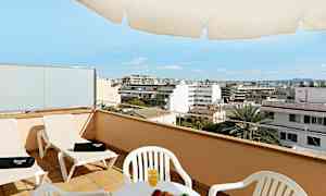 En terrass med stolar, ett bord med frukt och juice samt utsikt över en stad. (AI-genererad text)