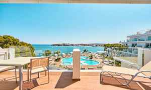 Hotellrumsvy mot poolområde och hav. (AI-genererad text)