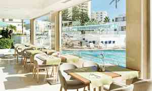 En restaurang med utsikt över en pool och solstolar. (AI-genererad text)