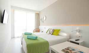 Ett modernt hotellrum med två enkelsängar och gröna detaljer. (AI-genererad text)