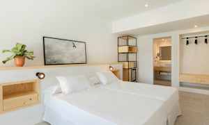 Ett ljust hotellrum med en dubbelsäng och inredning av trä. (AI-genererad text)