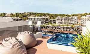 Terrass med bubbelpool och utsikt över hotellområde. (AI-genererad text)