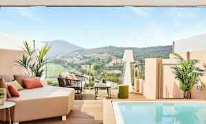 En terrass med utsikt över en grön dal och hus i fjärran, med sittmöbler och en liten pool. (AI-genererad text)