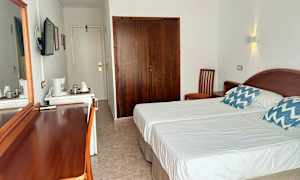 Sovrum med två enkelsängar, en garderob och möbler i trä. (AI-genererad text)