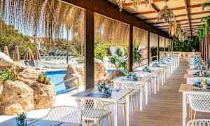 En terrassrestaurang med dukade bord vid en pool. (AI-genererad text)