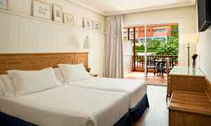 Ett hotellrum med två enkelsängar och en balkong utanför. (AI-genererad text)