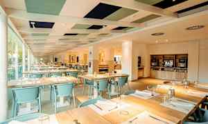 Inomhusmiljö av en restaurang med dukade bord och ljus interiör. (AI-genererad text)