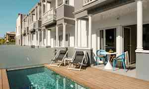 Byggnader med terrass intill en liten pool. (AI-genererad text)