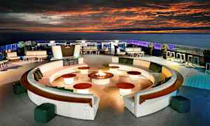 En takterrass med sittplatser, soffgrupper och ett centralt arrangemang med eld. (AI-genererad text)