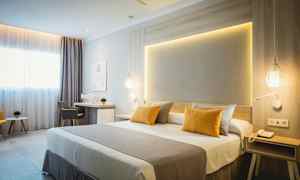 Ett modernt hotellrum med dubbelsäng, skrivbord och sittgrupp. (AI-genererad text)