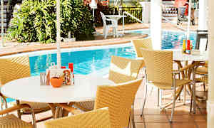 Utomhusområde med bord och stolar nära en pool. (AI-genererad text)