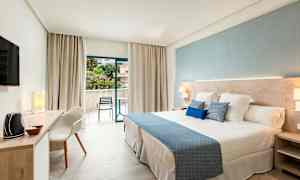 Ett modernt hotellrum med en stor säng och öppet till en balkong. (AI-genererad text)