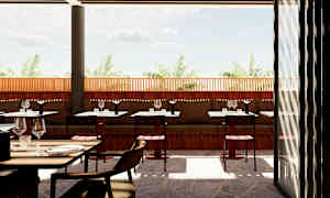 En utomhusrestaurang med bord och stolar, med en trävägg och utsikt mot palmer under en klar himmel. (AI-genererad text)