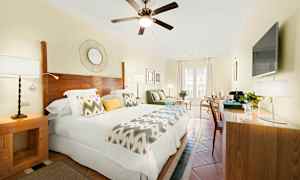 Ett ljust hotellrum med dubbelsäng, trädetaljer och modern inredning. (AI-genererad text)