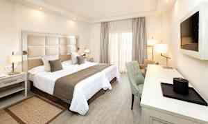 Ett hotellrum med en dubbelsäng, skrivbord och stol. (AI-genererad text)