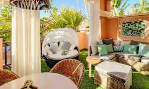 En möblerad balkong med solstolar, bord, och växtdekoration. (AI-genererad text)