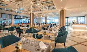 En restaurang med dukade bord och stolar. (AI-genererad text)