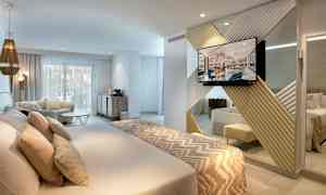 Modernt hotellrum med dubbelsäng, sittgrupp och TV. (AI-genererad text)