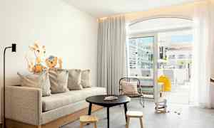 Modernt vardagsrum med soffbord, soffa och utsikt mot en terrass. (AI-genererad text)