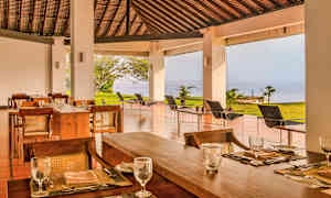 Uteservering med havsutsikt och trämöbler. (AI-genererad text)