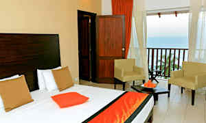 Bild av ett hotellrum med en säng, två stolar och balkong med utsikt över havet. (AI-genererad text)