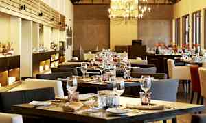 En elegant restaurang med dukade bord och en ljuskrona. (AI-genererad text)