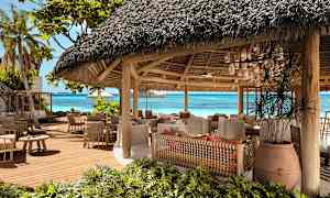 En öppen restaurang med halmtak nära stranden. (AI-genererad text)