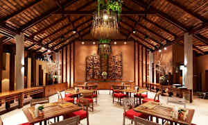 En elegant restaurang med trämöbler och varm belysning. Stolarna har röda dynor och det finns väggdekorationer samt hängande lampor med grönska. (AI-genererad text)