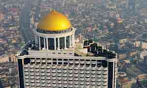 En skyskrapa med en guldfärgad kupol på toppen mot en stadsbakgrund. (AI-genererad text)