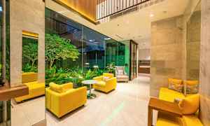 En lounge med gula soffor och glasvägg som vetter mot en grön trädgård. (AI-genererad text)