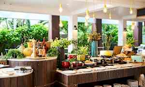 Buffébord med olika matalternativ och dekorationer, placerade i en öppen och ljus miljö. (AI-genererad text)