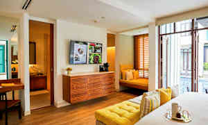 Ett modernt hotellrum med sittplatser och utsikt över en pool. (AI-genererad text)