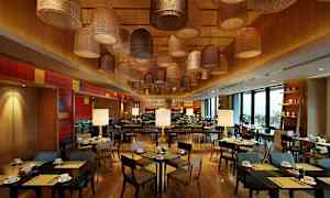 En restaurang med träinredning, moderna bord och stolar samt dekorativa taklampor av varierande design. (AI-genererad text)