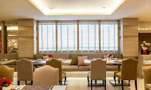 Bild av en modern restaurang med eleganta stolar och bord samt soffplatser, dekorerade med färska blommor. (AI-genererad text)