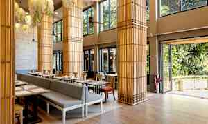 Ett ljust restaurangområde med stora fönster och dekorativa pelare. (AI-genererad text)