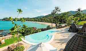 Bild av en pool vid stranden med utsikt över havet och grönska. (AI-genererad text)