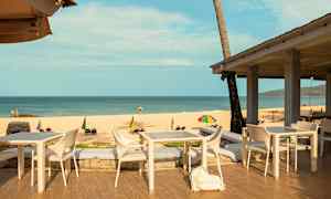 Uteservering nära stranden med havsutsikt. (AI-genererad text)