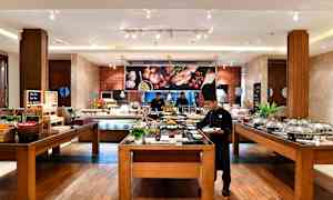 Bufféområde i restaurang med matstationer och sittplatser. (AI-genererad text)