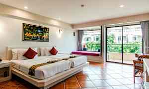 Ett hotellrum med två enkelsängar täckta med vita lakan, en tavla på väggen ovanför, och en glasdörr som leder till en balkong med utsikt över grönska. (AI-genererad text)