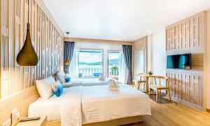 Hotellrum med två sängar, utsikt över havet och modern inredning. (AI-genererad text)