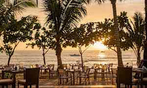 Uteservering vid stranden under solnedgången. (AI-genererad text)