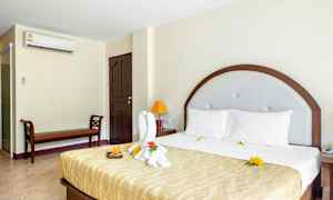 Hotellrum med en stor säng och dekorerad handduk. (AI-genererad text)