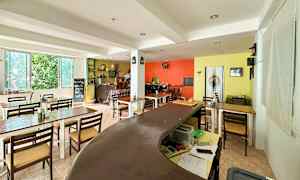 Bild på en inomhusmiljö med bord, stolar och färgglada väggar. (AI-genererad text)