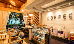 Ett elegant kafé med modern inredning, stora fönster och en synlig kaffedisk. (AI-genererad text)